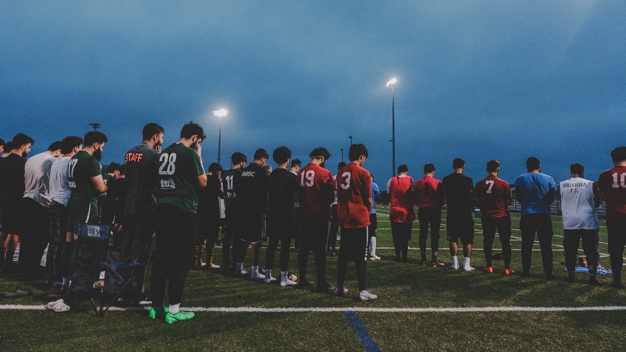 AASL players lined up on the field under the lights